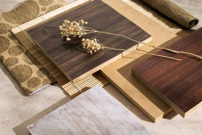 Wooden flooring samples with a decorative plant on a neutral background